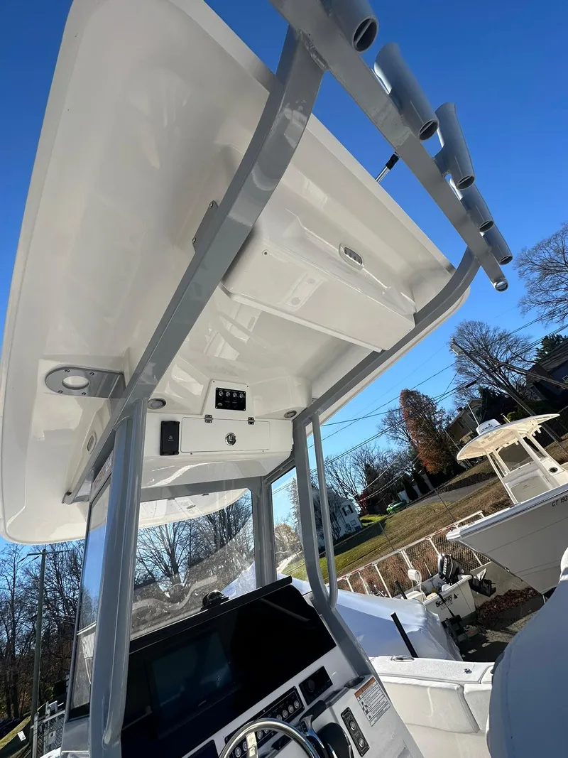 Slide: The Image of 2025 Sea Fox 248 Commander boat console and T-top under clear blue sky. - 14