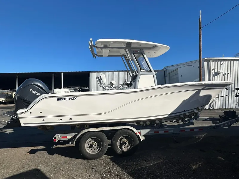 Slide: The Image of 2025 Sea Fox 248 Commander boat on trailer, side view, clear blue sky. - 3