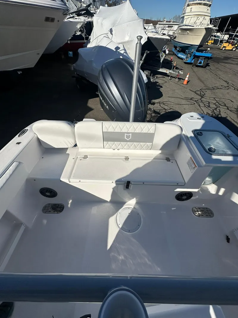Slide: The Image of 2025 Sea Fox 248 Commander boat interior with seating and motor, docked outdoors. - 8
