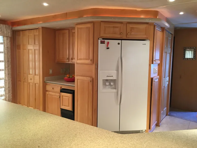 Slide: The Image of Spacious kitchen in 2002 Sharpe Just Because Trip 33 houseboat with wooden cabinets and white appliances. - 10