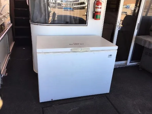Slide: The Image of White chest freezer on a boat deck, near a fire extinguisher and sliding door. - 26