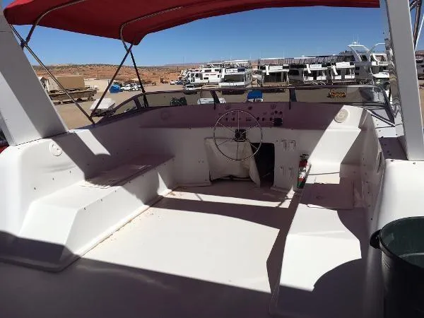 Slide: The Image of 2002 Sharpe Just Because Trip 33 boat interior with red canopy and steering wheel. - 28