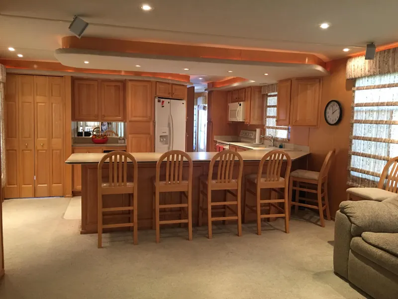 Slide: The Image of Spacious kitchen in 2002 Sharpe Just Because Trip 33 houseboat with wooden cabinetry and bar stools. - 3