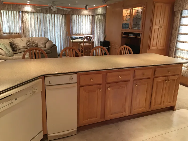 Slide: The Image of Spacious kitchen in 2002 Sharpe Just Because Trip 33 houseboat with wooden cabinets and island. - 7