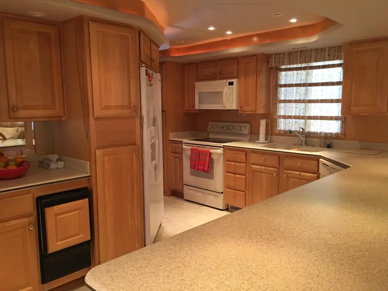 Slide: The Image of Spacious kitchen in 2002 Sharpe Just Because Trip 33 houseboat with wooden cabinets and modern appliances. - 9