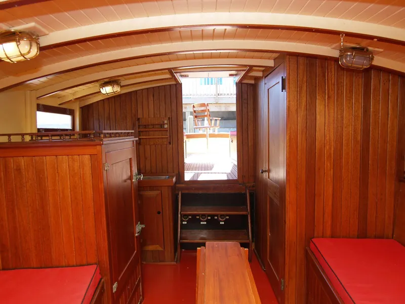 Slide: The Image of Interior of 1933 Frank M Weeks Cruiser with wooden paneling and red cushions. - 12