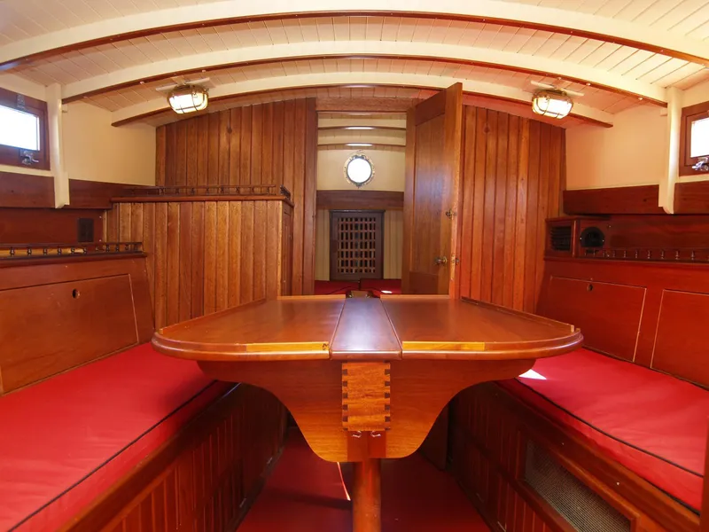 Slide: The Image of Interior of 1933 Frank M Weeks Cruiser with wooden paneling and red cushioned seating. - 16