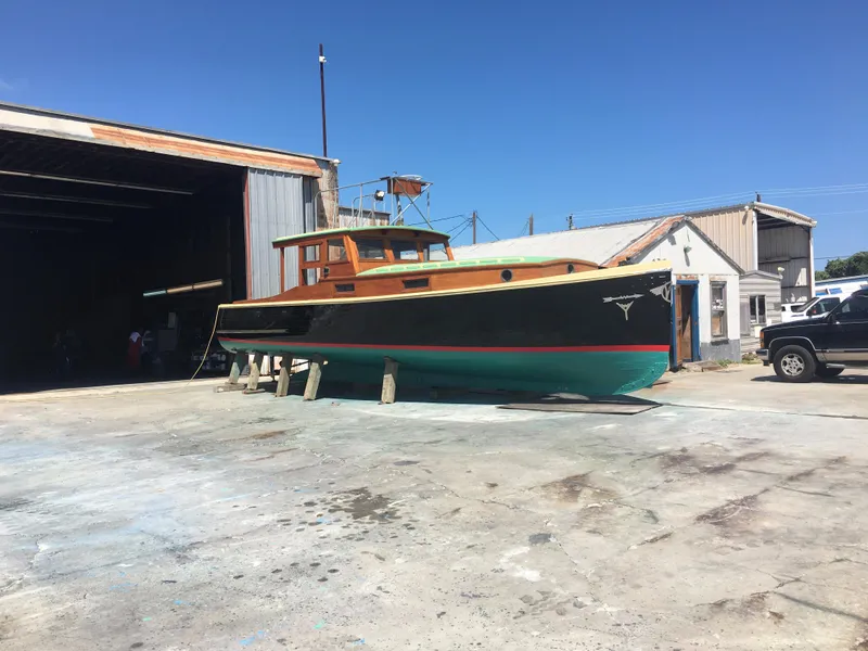 Slide: The Image of Historic 1933 Frank M Weeks Cruiser docked outside a warehouse under clear blue skies. - 21
