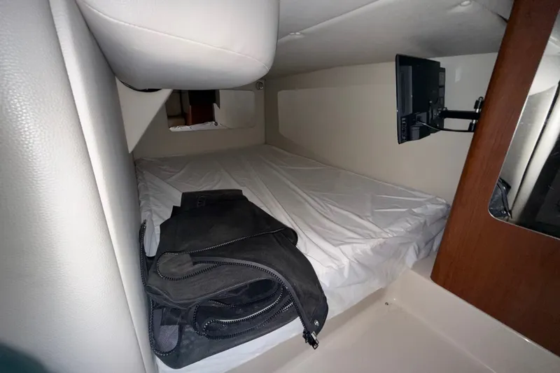 Slide: The Image of 2003 Chaparral Signature 320 cabin interior with bed, TV, and bag. - 16