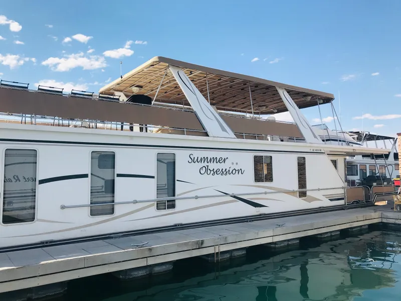 The Image of 2005 Stardust Cruisers houseboat "Summer Obsession" docked, featuring spacious upper deck and modern design. - 0