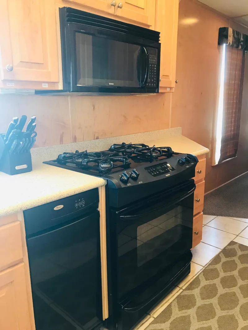 Slide: The Image of Kitchen area in 2005 Stardust Cruisers Summer Obsession, featuring stove, microwave, and knife set. - 12