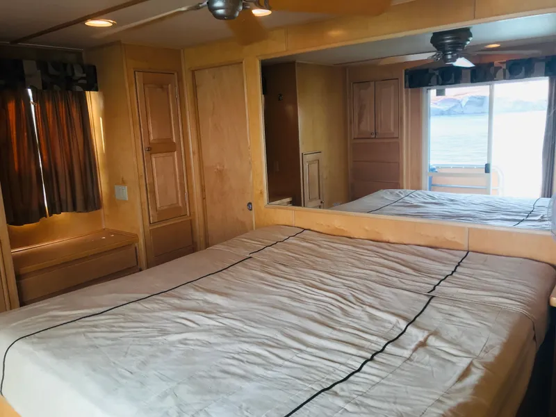 Slide: The Image of Luxurious 2005 Stardust Cruisers bedroom with large bed, wood paneling, and waterfront view. - 27