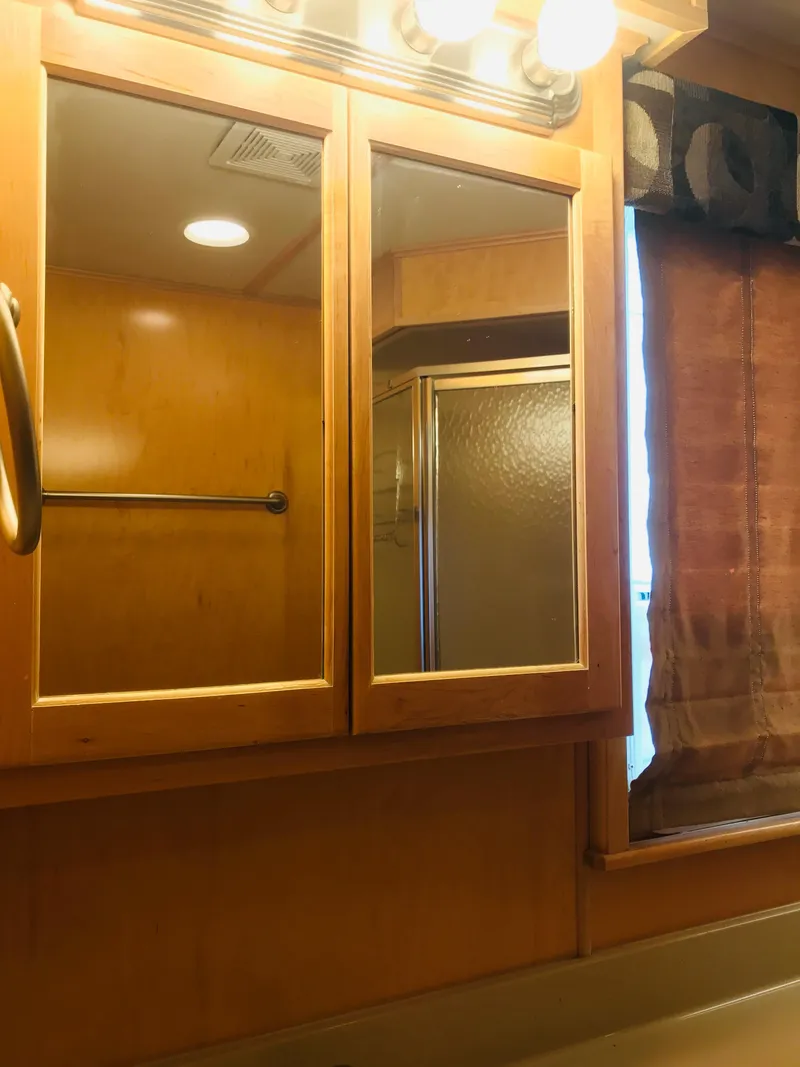 Slide: The Image of Bathroom interior of 2005 Stardust Cruisers Summer Obsession, featuring wooden cabinets and a shower. - 33