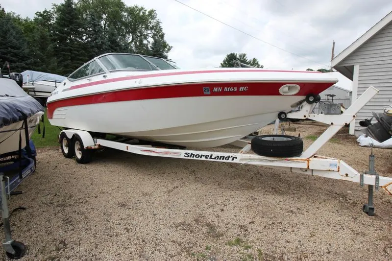 The Image of 1997 Cobalt 272 BR boat on trailer, parked outdoors, featuring red and white design. - 1