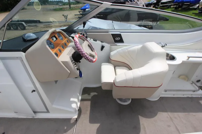 Slide: The Image of Interior of a 1997 Cobalt 272 BR boat with white seating and dashboard. - 11