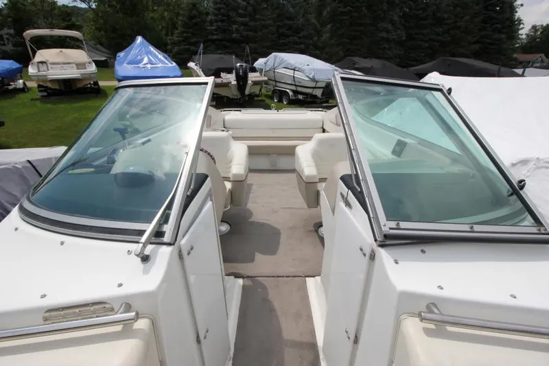 Slide: The Image of 1997 Cobalt 272 BR boat interior with seating and windshield, parked outdoors. - 21
