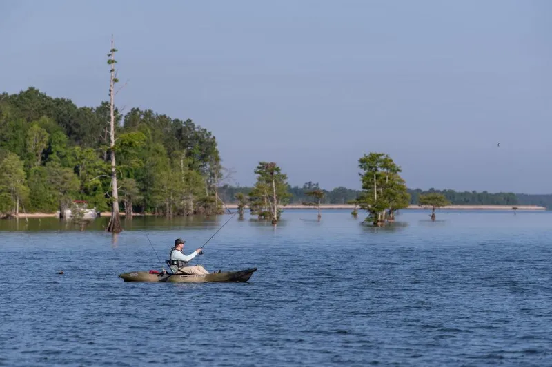 Slide: The Image of Person fishing on a 2022 Native Watercraft Stingray 11.5 kayak in a serene lake. - 4