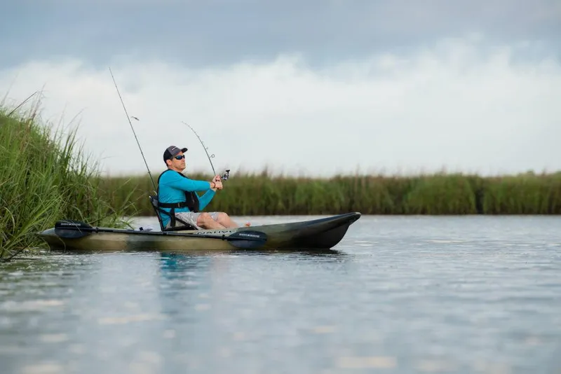 Slide: The Image of Man fishing from a 2022 Native Watercraft Stingray 11.5 kayak in a serene lake. - 6