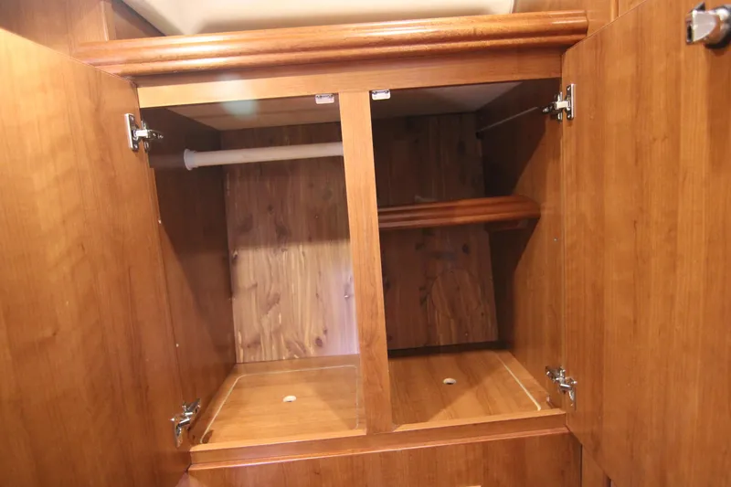 Slide: The Image of A wooden cabinet with two open doors and a shelf inside. - 45