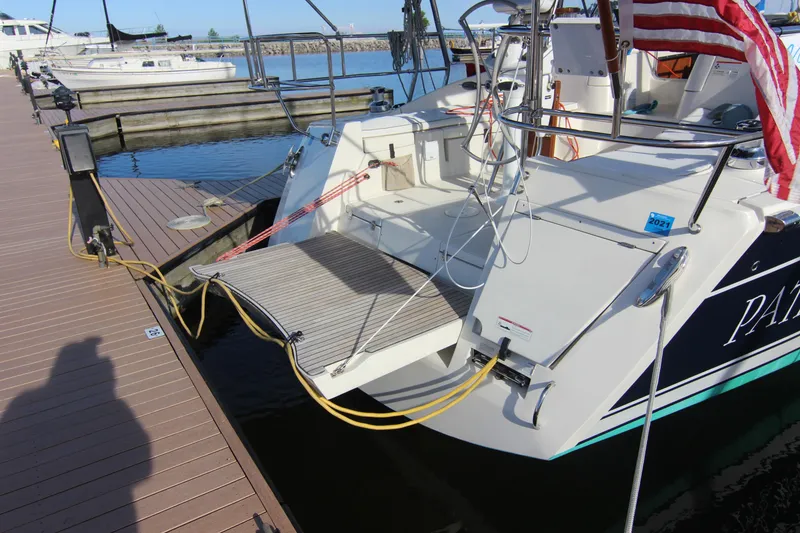 Slide: The Image of A 2015 Marlow-Hunter 37 docked, featuring a swim platform at the stern. - 3