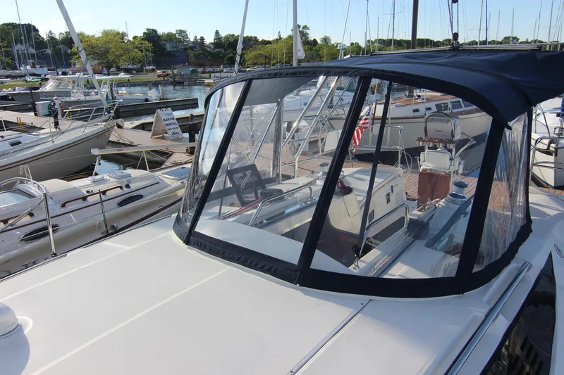 Slide: The Image of A 2015 Marlow-Hunter 37 sailboat docked in a marina. It features a modern cockpit with a cover. - 15