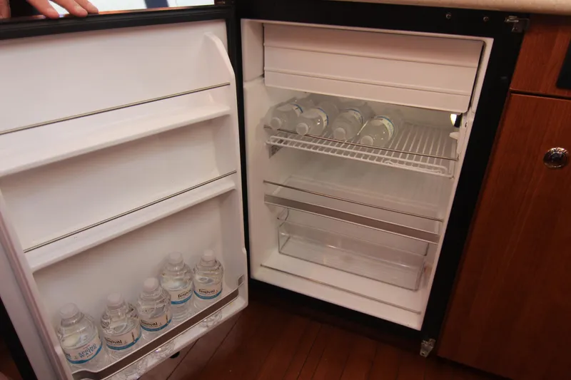 Slide: The Image of An open fridge with water bottles in the door compartments and on the shelves. - 34