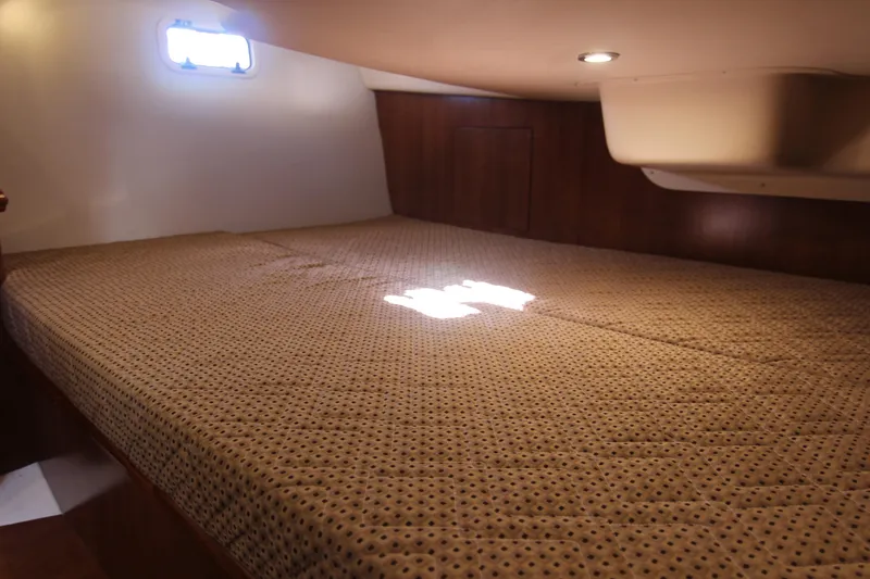 Slide: The Image of The 2015 Marlow-Hunter 37 cabin features a large bed with patterned cover and wooden walls. - 43
