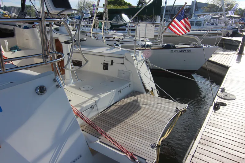 Slide: The Image of Stern of a 2015 Marlow-Hunter 37 sailboat at a dock with an American flag. - 4