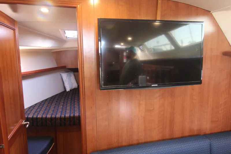 Slide: The Image of Interior of a 2015 Marlow-Hunter 37 with wood paneling, a TV, and a sleeping cabin. - 40