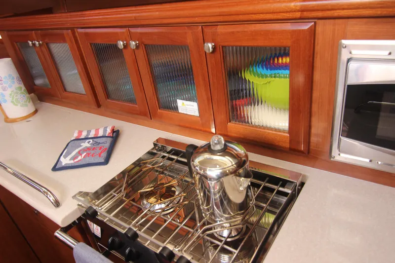 Slide: The Image of The galley of a 2015 Marlow-Hunter 37 with wooden cabinets and a stove. - 31