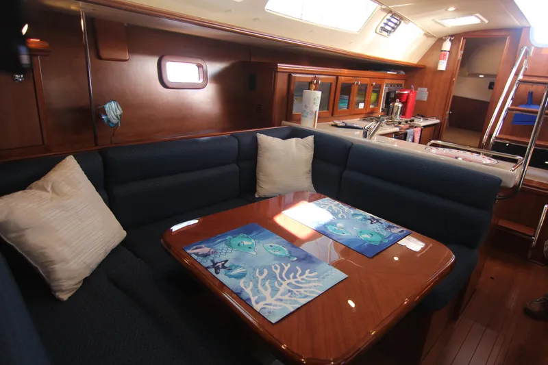 Slide: The Image of The interior of a 2015 Marlow-Hunter 37 features a cozy seating area with a wooden table and blue upholstery. - 38
