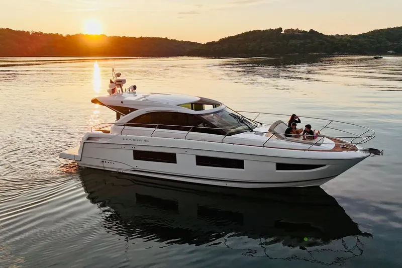 Slide: The Image of 2017 Jeanneau Leader 46 yacht cruising at sunset on a serene lake. - 46