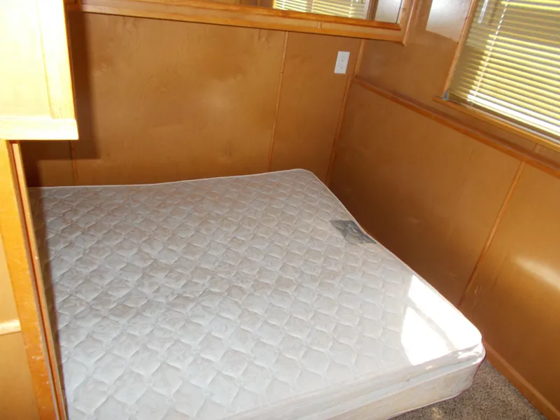 Slide: The Image of 2003 Stardust Cruisers For Shore 6 bedroom with mattress, wooden walls, and window blinds. - 13