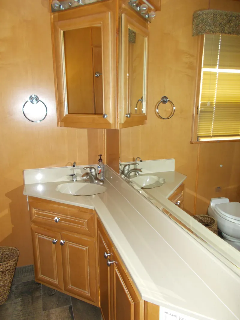 Slide: The Image of 2003 Stardust Cruisers For Shore 6 bathroom with dual sinks and wooden cabinetry. - 19