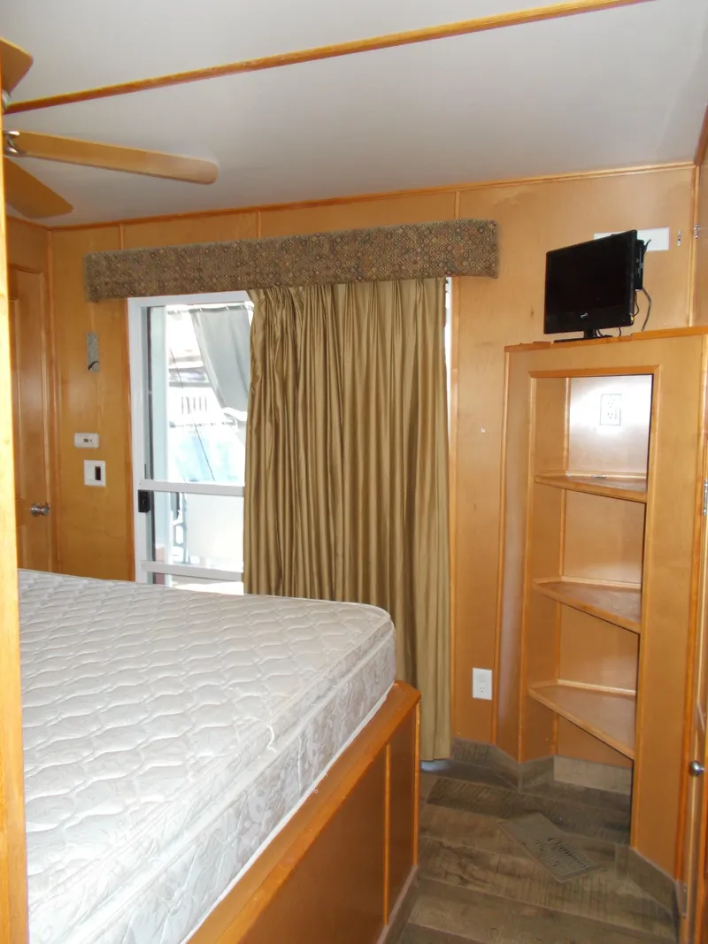 Slide: The Image of Interior of 2003 Stardust Cruisers houseboat with bed, TV, and sliding door. - 24