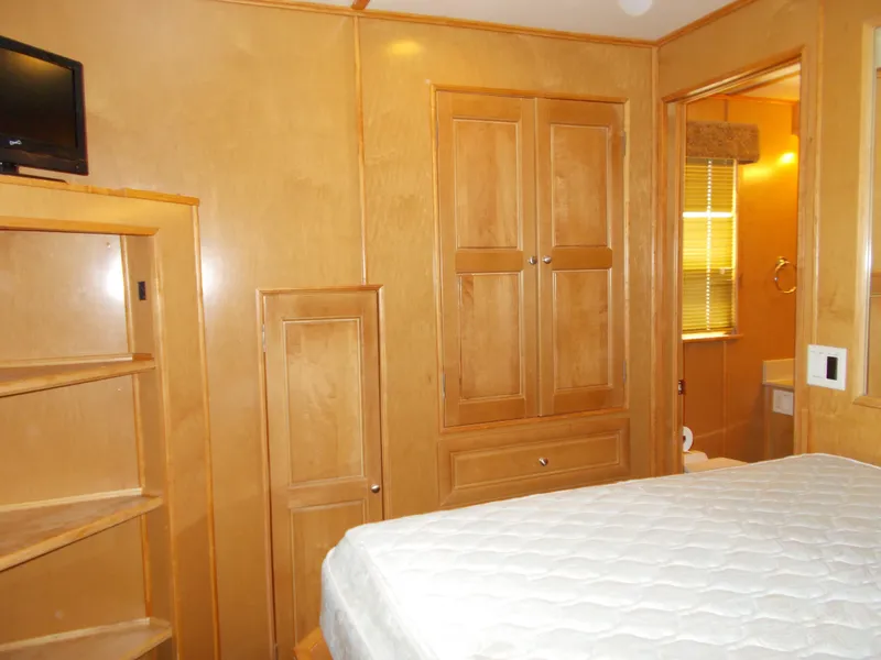 Slide: The Image of Bedroom interior of 2003 Stardust Cruisers For Shore 6, featuring wood cabinetry and a cozy bed. - 26