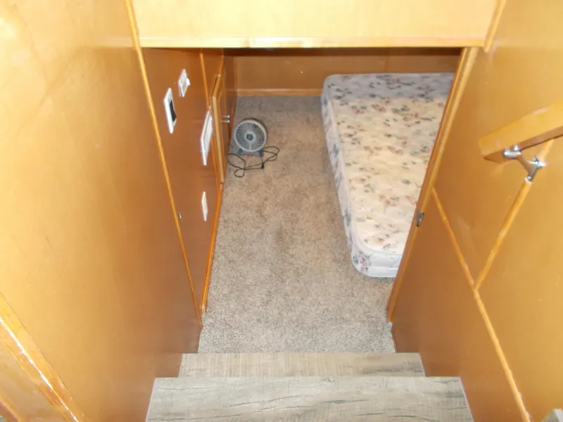 Slide: The Image of 2003 Stardust Cruisers cabin interior with bed, carpet, and small fan. - 27