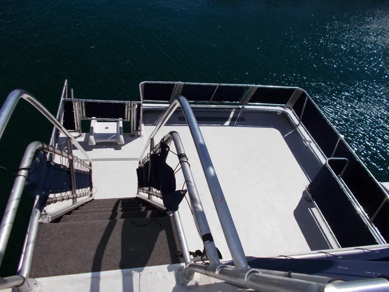 Slide: The Image of Stardust Cruisers 2003 houseboat deck with stairs, overlooking calm water. - 43