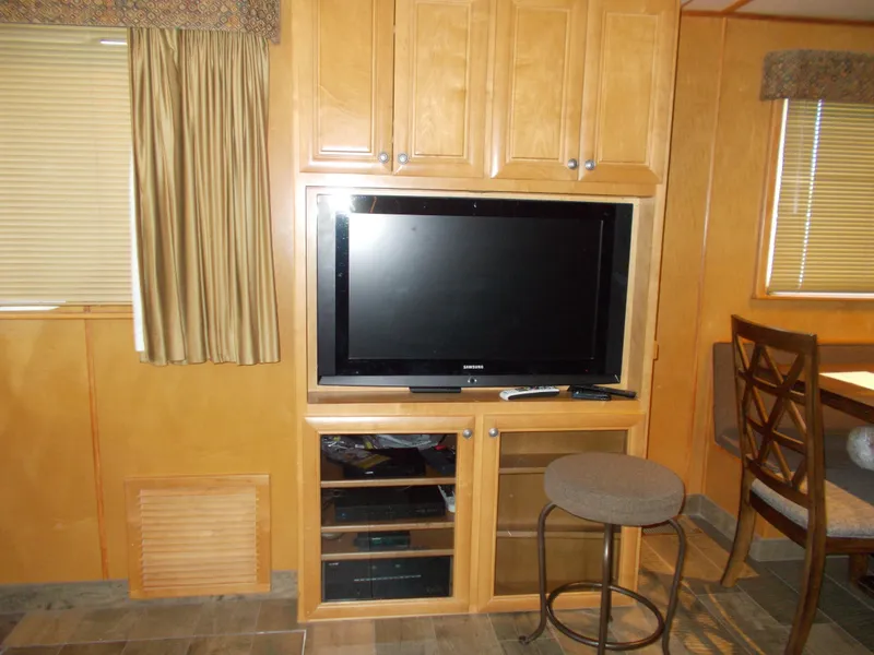 Slide: The Image of 2003 Stardust Cruisers interior with TV, wooden cabinets, and seating area. - 7