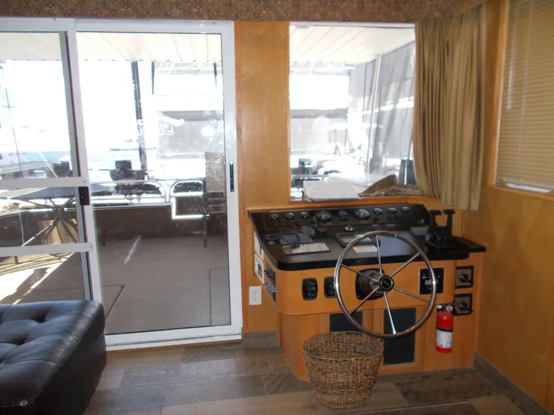 Slide: The Image of 2003 Stardust Cruisers For Shore 6 helm with steering wheel, sliding glass door, and cozy interior. - 8