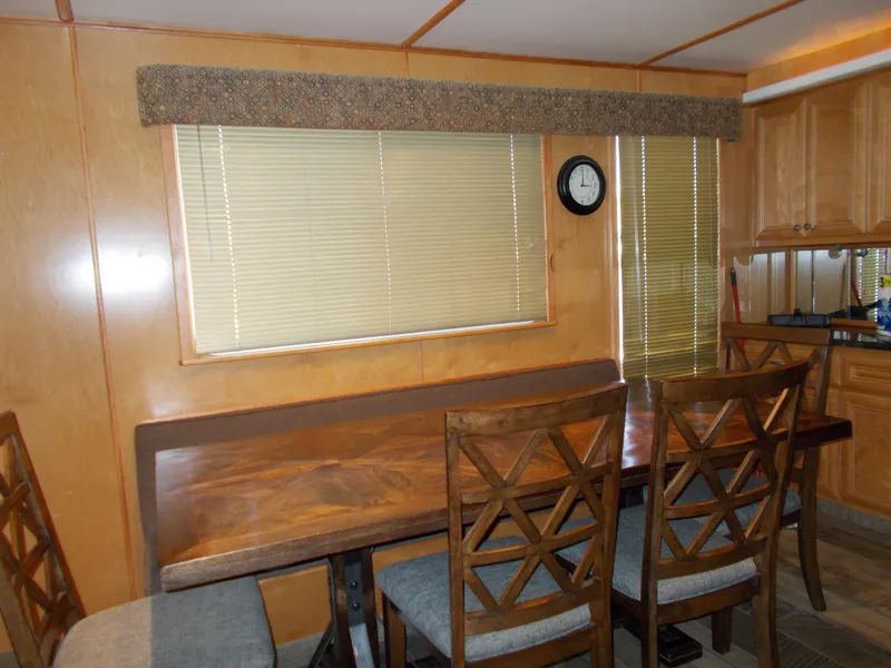 Slide: The Image of Dining area in 2003 Stardust Cruisers For Shore 6 houseboat with wooden table and chairs. - 9