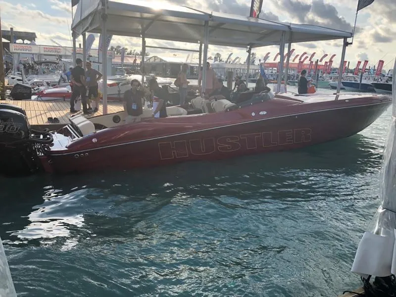 Slide: The Image of 2025 Hustler 39 Shotgun speedboat docked at a marina event. - 3