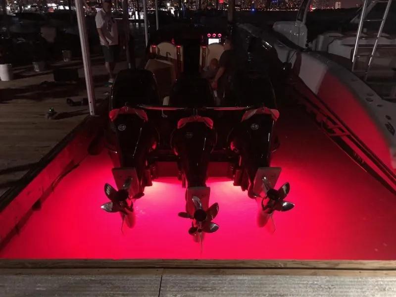 Slide: The Image of 2025 Hustler 39 Shotgun boat with illuminated red underwater lights at night. - 4