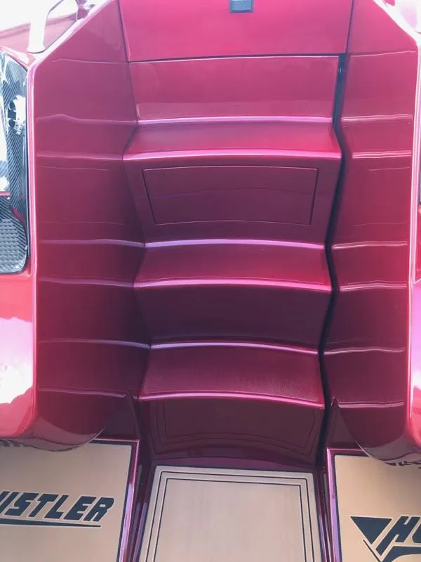 Slide: The Image of 2025 Hustler 39 Shotgun boat interior with red seating and Hustler branding. - 7