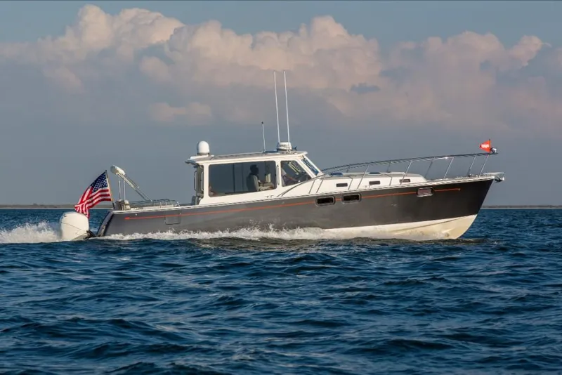 Slide: The Image of 2023 MJM 43z motor yacht cruising on open water with American flag. - 3