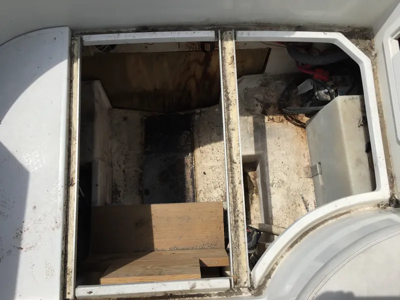 Slide: The Image of 1992 Chris-Craft 232 Crowne boat interior showing storage compartments and engine area. - 10