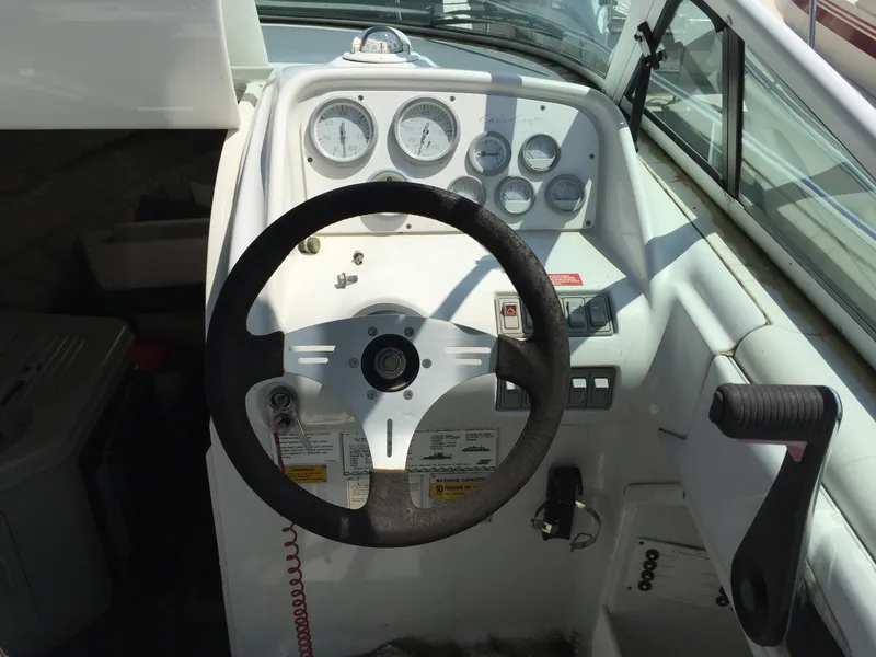 Slide: The Image of 1992 Chris-Craft 232 Crowne boat dashboard with steering wheel and gauges. - 2