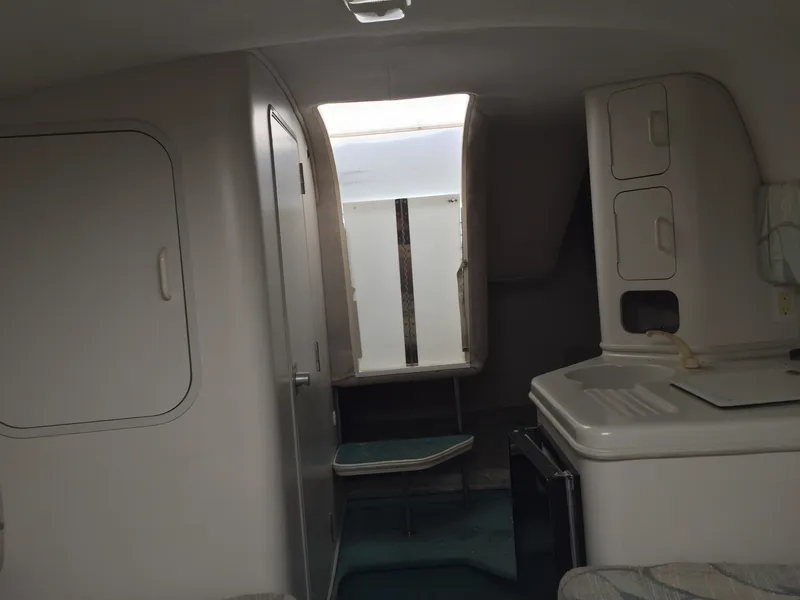 Slide: The Image of Interior of 1992 Chris-Craft 232 Crowne boat, featuring compact cabin and kitchenette. - 4