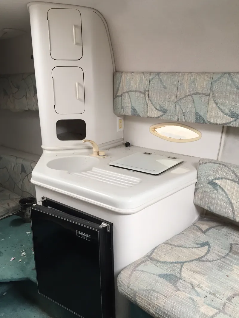 Slide: The Image of 1992 Chris-Craft 232 Crowne cabin interior with kitchenette and seating area. - 5