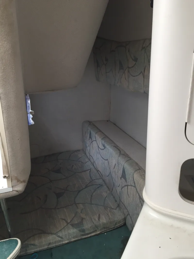 Slide: The Image of 1992 Chris-Craft 232 Crowne cabin interior with patterned cushions and compact design. - 7
